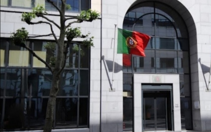 Fachada de um edifício institucional com a bandeira de Portugal hasteada, representando a Secção Consular da Embaixada de Portugal em Bruxelas.